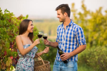 Young beautiful winemaker couple tasting wine